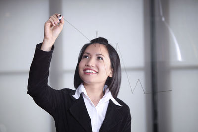 Businesswoman writing on glass board