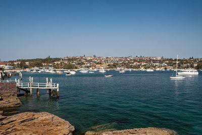 Sailboats in sea against clear sky