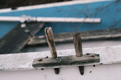 Close-up of rusty chain on wooden railing