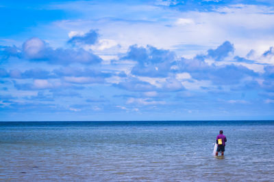 Rear view of man standing in sea