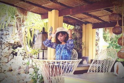 Young woman sitting at table in gazebo