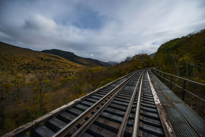 Abandoned railroad trestle high above new england autumn forest