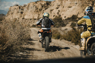 Rear view of man riding motorcycle on land