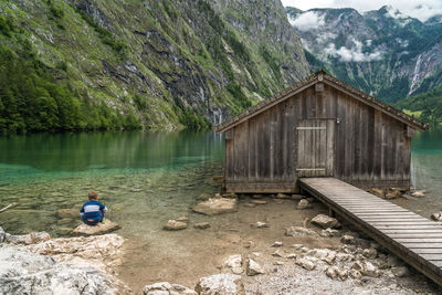 Man sitting on rock by lake