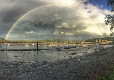 Rainbow over beach against sky