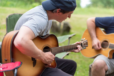 Midsection of man playing guitar