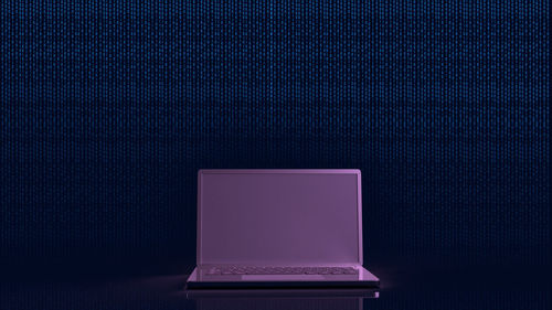 Close-up of laptop on table against black background