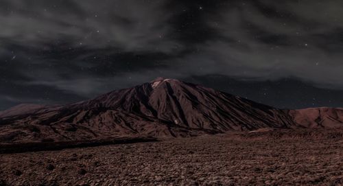 Scenic view of snowcapped mountains against sky at night