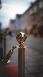 Close-up of metal railing against buildings in city