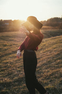 Side view of woman standing on field