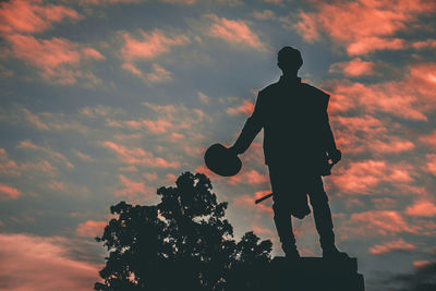 Low angle view silhouette of statue against sky during sunset
