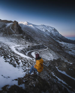 Rear view of person on snowcapped mountain against sky