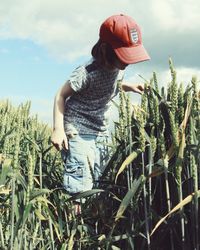 Woman standing by plants against sky