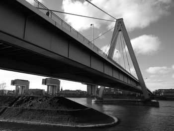 Bridge over river against sky in city