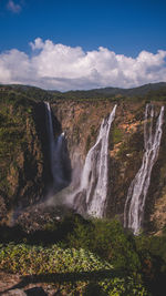 Scenic view of waterfall against sky