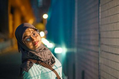 Portrait of young woman looking away at night