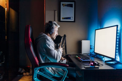 Gamer doing online streaming while playing game on computer at home