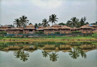 Reflection of palm trees and building in lake