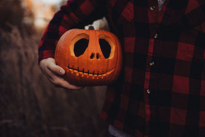 Human hand holding pumpkin