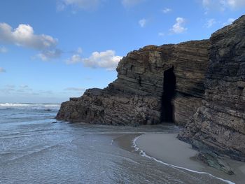 Rock formations by sea against sky