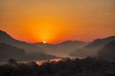 Scenic view of silhouette mountains against the romantic sky at sunset