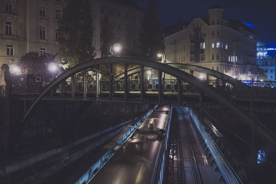 Illuminated bridge in city at night