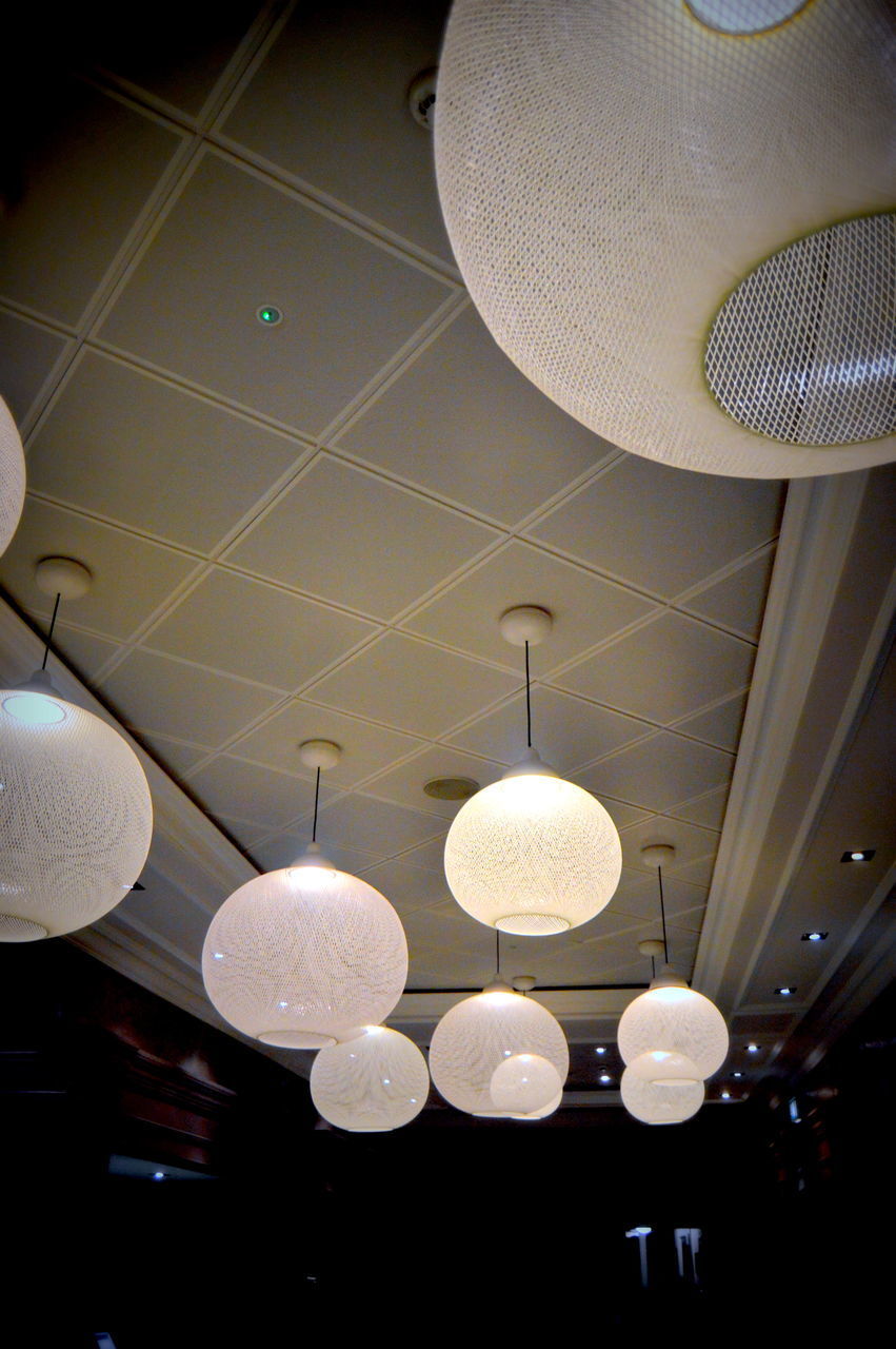 LOW ANGLE VIEW OF ILLUMINATED CHANDELIER HANGING FROM CEILING