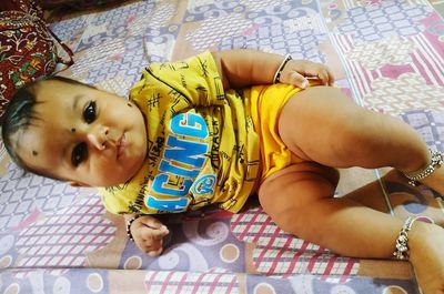 High angle view of cute baby lying on bed