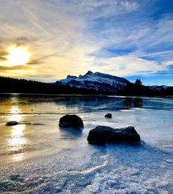 Scenic view of frozen lake against sky during sunset