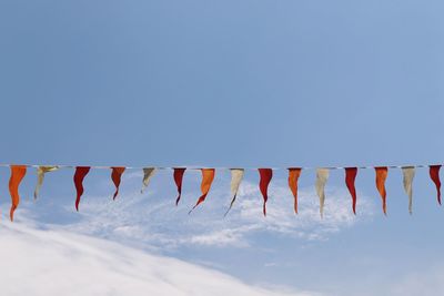 Low angle view of flags hanging against sky during winter