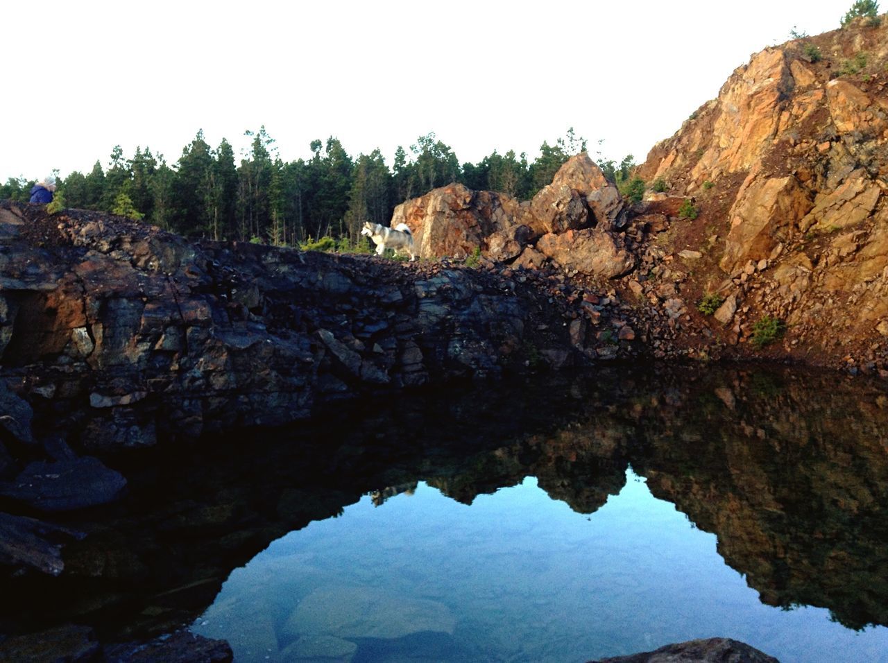 rock formation, rock - object, tranquility, tranquil scene, water, scenics, beauty in nature, nature, rock, cliff, geology, rocky mountains, eroded, mountain, clear sky, tree, physical geography, sky, reflection, idyllic