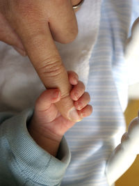 Cropped image of father hand holding baby boy