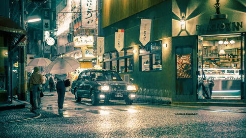 Cars on illuminated street in city at night