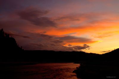 Scenic view of silhouette mountains against orange sky