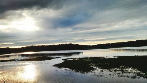 Scenic view of river against cloudy sky