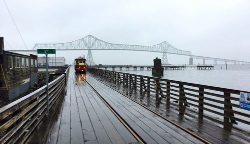 Tram on bridge by sea against sky