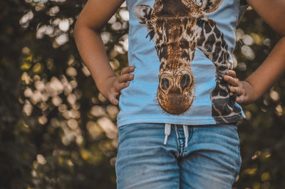 Midsection of boy holding umbrella standing outdoors