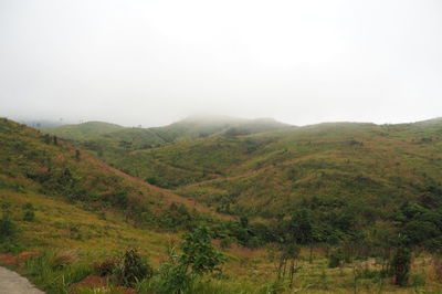 Scenic view of green landscape and mountains against sky