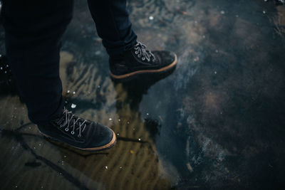 Low section of man standing in water