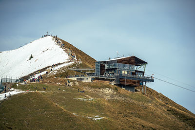 Traditional windmill on snowcapped mountain against sky