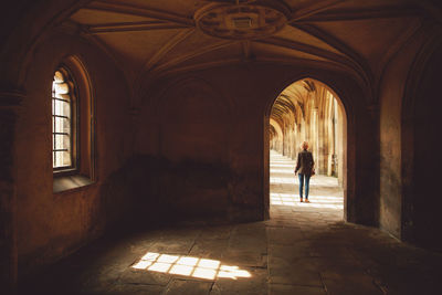 Rear view of woman standing in corridor