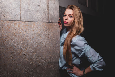 Portrait of beautiful woman standing against wall