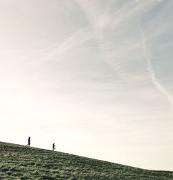 Distant view of people on hill against sky