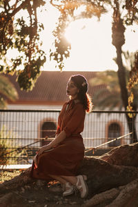 Portrait of woman sitting against trees