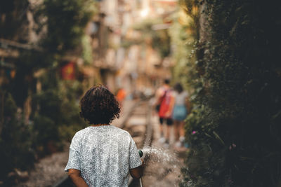 Rear view of people walking on plants