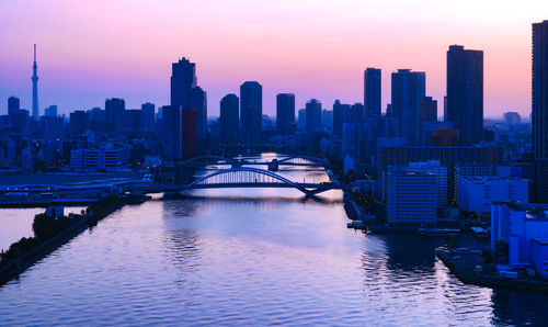 Modern buildings in city against sky during sunset