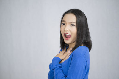 Portrait of beautiful young woman standing against white background