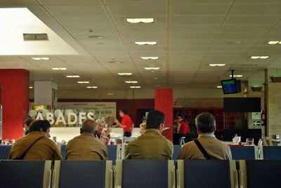 Rear view of people sitting in corridor