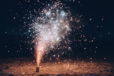 Burning firework at beach during night