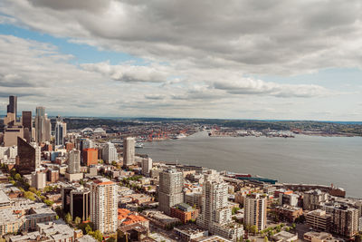 High angle view of buildings by sea against sky